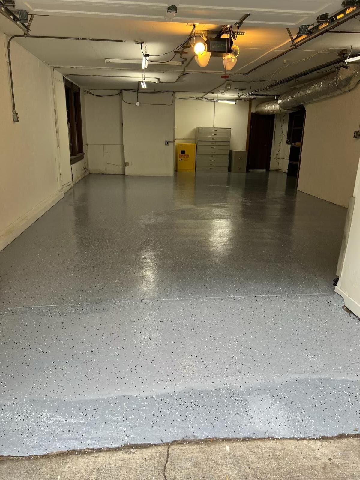 Freshly painted gray epoxy floor in commercial basement by Santi Painting Inc.