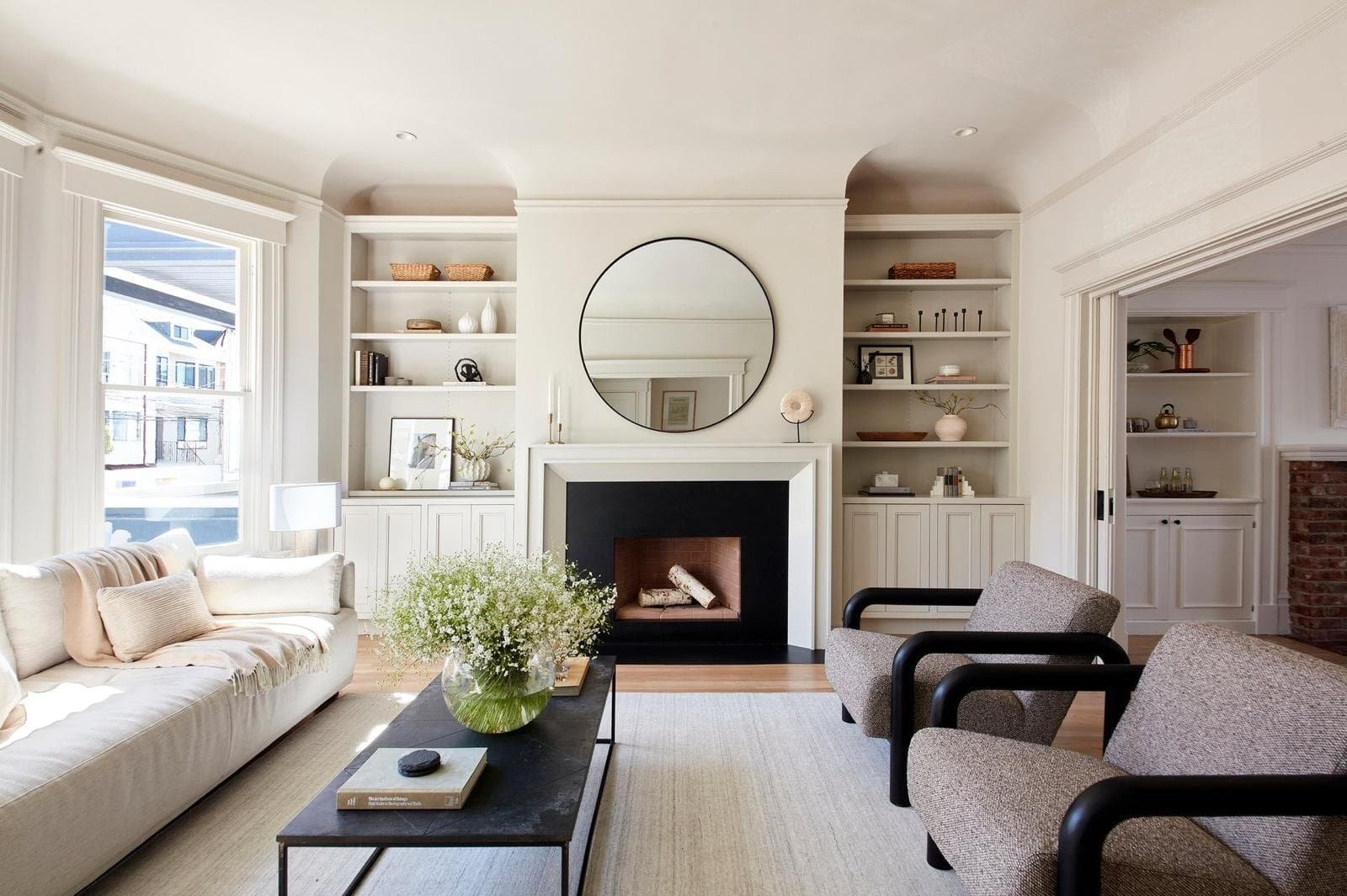 Modern living room with fireplace, mirror, and comfortable seating.