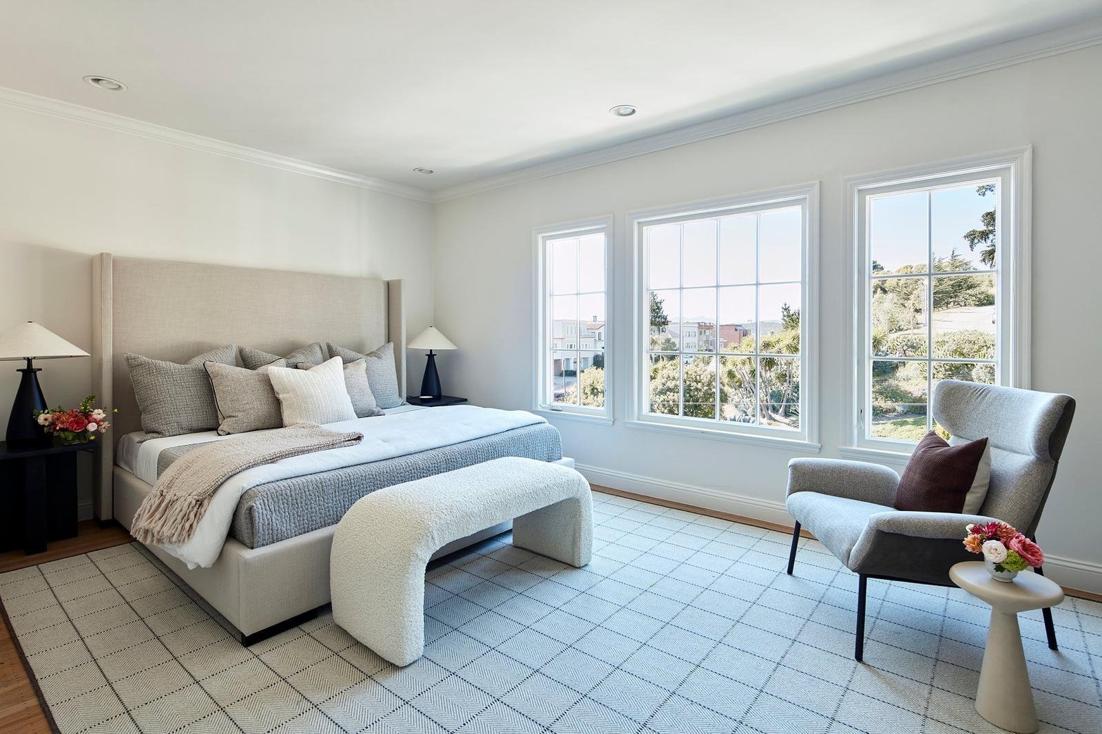 Bright bedroom with large windows and modern decor for a relaxing atmosphere.
